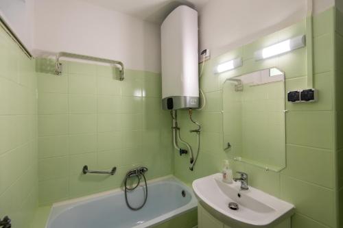 un bagno verde con lavandino e doccia di Kis János Apartman a Sopron