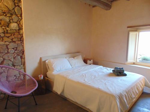 een slaapkamer met een bed, een stoel en een raam bij Montalcinello Casavolta WIFI, aria condizionata in Montingegnoli