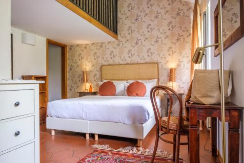 a bedroom with a bed and a desk and a chair at Villa Borgo Duino in Duino