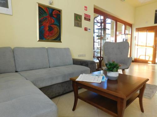 a living room with a couch and a coffee table at Hotel Kumánia in Kisújszállás