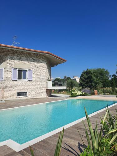 a swimming pool in front of a house at Appartamenti Villa Gloria in Peschiera del Garda