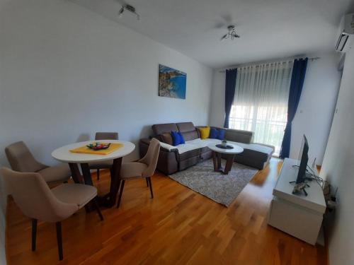 ein Wohnzimmer mit einem Sofa und einem Tisch in der Unterkunft Lux Apartment Talija in Budva