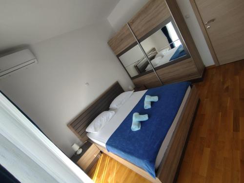 Kleines Zimmer mit einem Bett mit blauer Bettwäsche und weißen Kissen in der Unterkunft Lux Apartment Talija in Budva