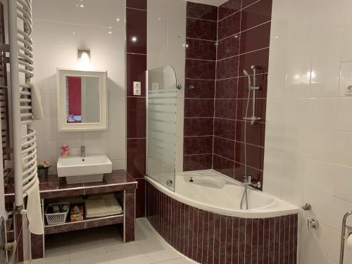 a bathroom with a bath tub and a sink at King Residences in Budapest