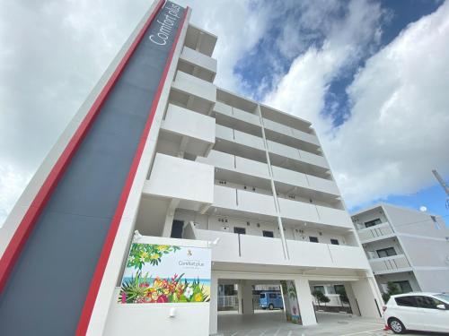 a building with a sign in front of it at Comfort Plus in Chatan