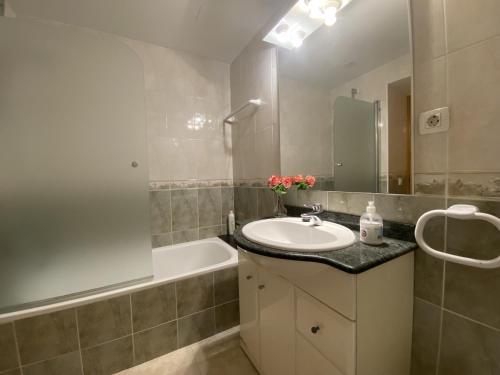 W łazience znajduje się umywalka i wanna. w obiekcie R123 Apartamento en la planta baja con piscina cerca de la playa w mieście Calafell