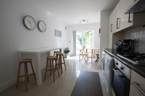 a kitchen with a counter and some stools in it at Tooting Rooms & Studio by PrimeCityHosts in London