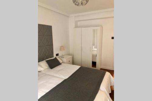 ein Schlafzimmer mit einem großen weißen Bett mit einer schwarzen Decke in der Unterkunft Piso en el centro de Oviedo in Oviedo