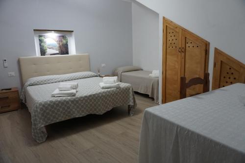 sypialnia z 2 łóżkami, stołem i lustrem w obiekcie Casa Vacanze B&B Ondes w mieście Camerota