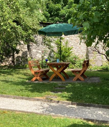 a picnic table with an umbrella and two benches at Frühstückspension Josefinum in Bad Aussee