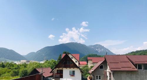 a group of houses with mountains in the background at Piatra Craiului Residence Zărnești in Zărneşti