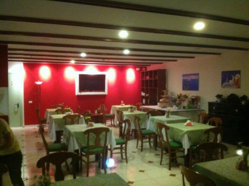 a restaurant with tables and chairs and a red wall at Bellevue del Golfo Hotel & Spa in Sferracavallo