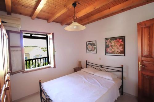 a bedroom with a bed and a window at Sonia's Apartment in Fiscardo Waterfront in Fiskardho