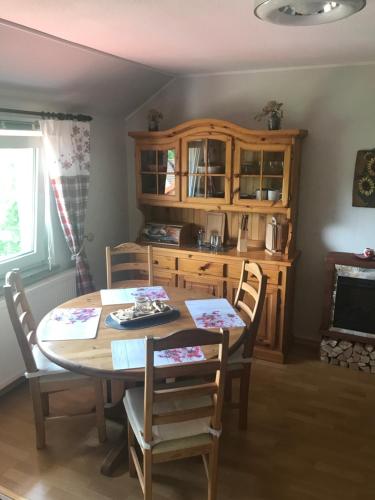 a dining room with a table and chairs and a kitchen at Ferienwohnung am Hochrhöner 