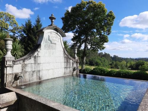a swimming pool in a stone wall with water in it at Cazal Da Lamella in Fafe