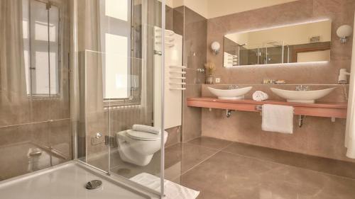 La salle de bains est pourvue de 2 lavabos, de toilettes et d'une douche. dans l'établissement Hotel van Bebber, à Xanten