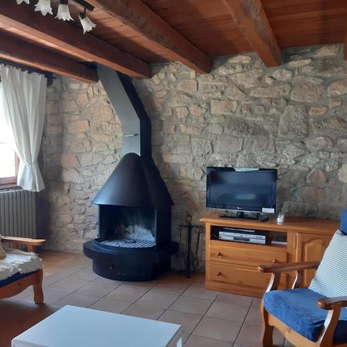 a living room with a fireplace and a tv at Les Cases De Borrells in Lladurs