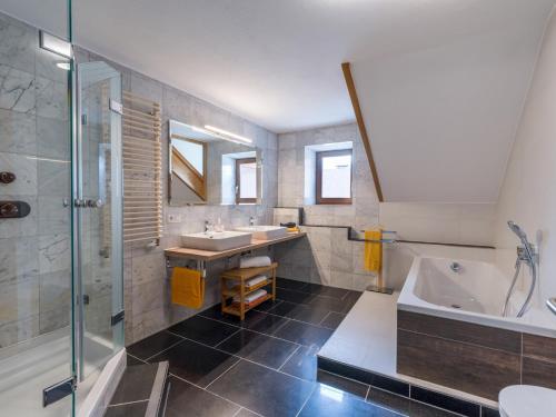 a bathroom with two sinks and a tub and a shower at Ferienwohnung Neuheim in Niederau