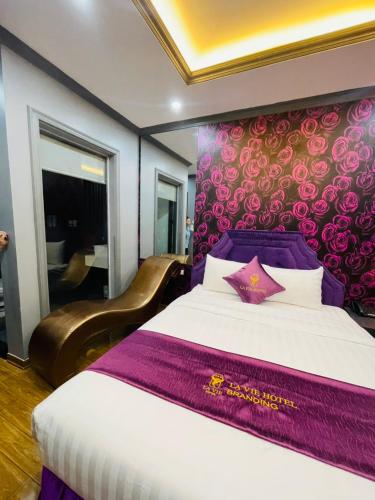a bedroom with a large bed with a purple headboard at Lavie Hotel in Hanoi