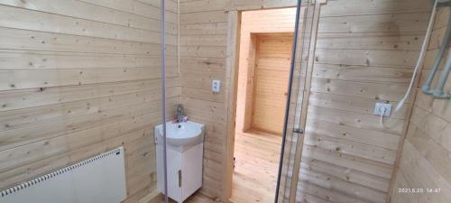 a wooden bathroom with a toilet and a shower at ZHANUYA HOUSE in Borovoye