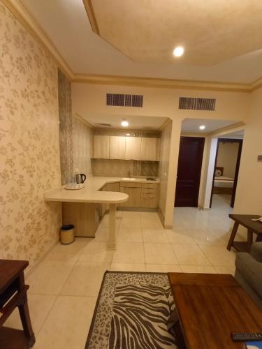 a large kitchen with a table and a counter at سارة للشقق المخدومة Sara Serviced Apartments in Al Khobar