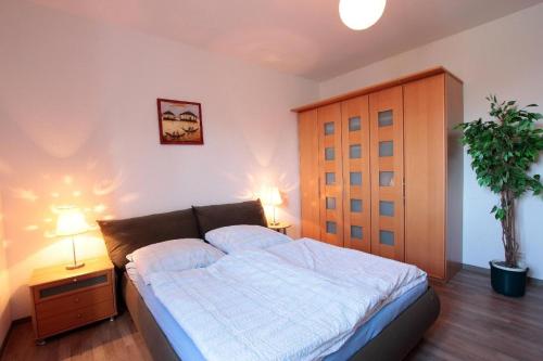 1 dormitorio con 1 cama con 2 lámparas y una planta en Ferienwohnung-Bieberblick, en Greifswald