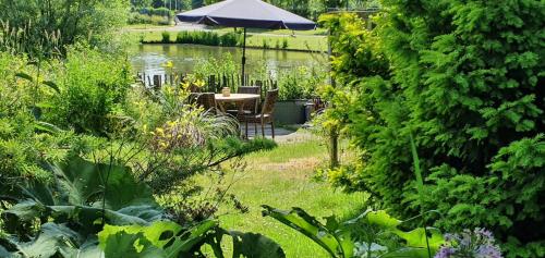 a garden with an umbrella and a table and chairs at Verborgen Parel aan de Rotte in Rotterdam