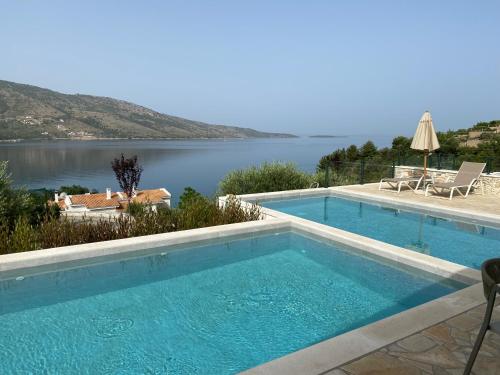 a swimming pool with a view of the water at Elia Luxury Suites in Plataria