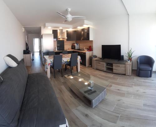 a living room with a couch and a table at appartement T3 Saint-Cyprien plage in Saint-Cyprien
