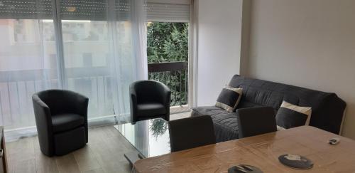 a living room with a couch and a table and chairs at appartement T3 Saint-Cyprien plage in Saint-Cyprien