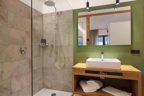 a bathroom with a sink and a shower at Archehof Hochzirm Lodge Johanna in Campo Tures