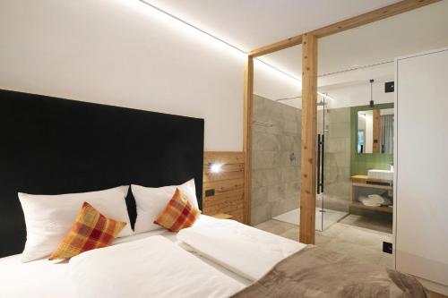 a bedroom with a bed and a glass shower at Archehof Hochzirm Lodge Johanna in Campo Tures