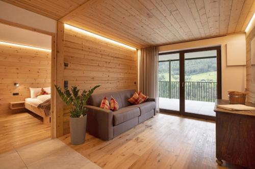 a living room with a couch and a bedroom at Archehof Hochzirm Lodge Greti in Campo Tures