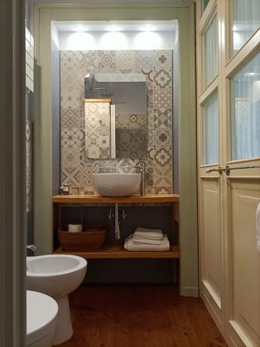 a bathroom with a sink and a toilet and a mirror at Agriturismo IL FRA' in Tigliole
