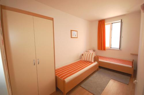 Cette petite chambre dispose d'un banc et d'une fenêtre. dans l'établissement Apartment Blanka, à Njivice