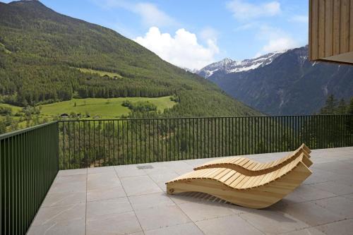 a bench on a balcony with a view of mountains at Archehof Hochzirm Lodge Anna in Campo Tures