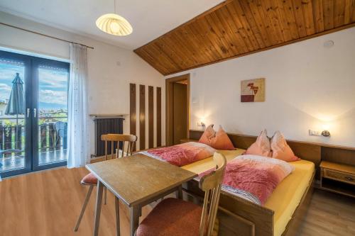 a room with two beds and a table and a window at Apartment Gantkofel Leilichhof in Lana