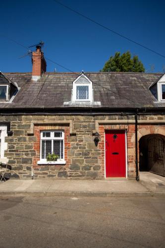 a brick house with a red door on a street at Arthur Street cottage in Hillsborough