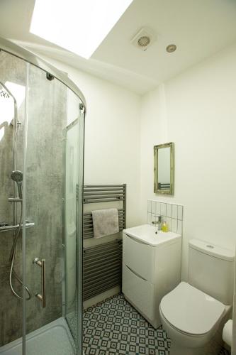 a bathroom with a shower and a toilet and a sink at Arthur Street cottage in Hillsborough
