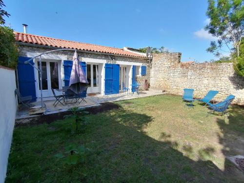a house with a yard with blue chairs at Le Chai de Saint-Pierre in Saint-Pierre-dʼOléron