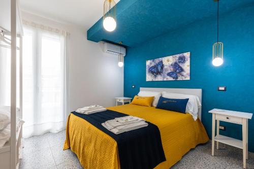 a bedroom with blue walls and a yellow bed at La Scala Suite in Realmonte