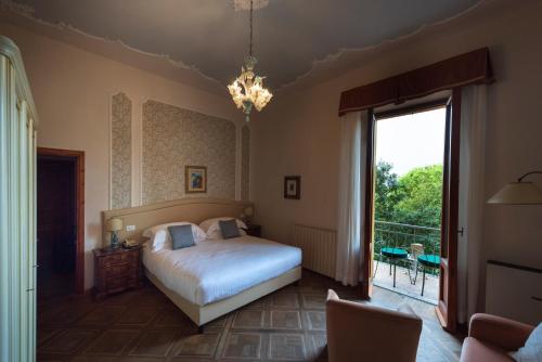 a bedroom with a bed and a large window at Villa Scacciapensieri Boutique Hotel in Siena