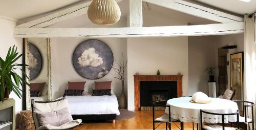 un salon avec un lit et une table dans l'établissement Appartement ciel de fugeres, au Puy-en-Velay