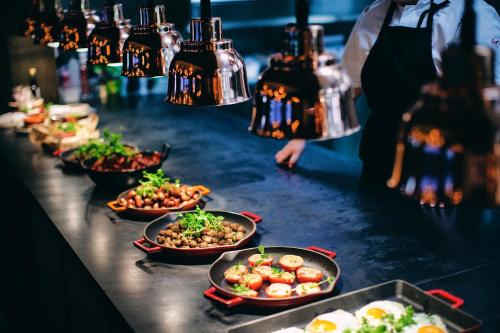 a buffet line with plates of food on a table at Stord Hotel in Stord