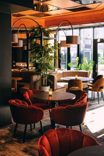 a restaurant with tables and chairs and plants at Stord Hotel in Stord