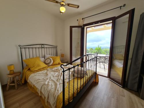 een slaapkamer met een bed en een glazen schuifdeur bij Alghero - House with Panoramic View immersed in full nature in Alghero