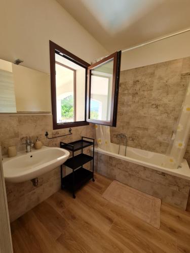 bagno con lavandino e vasca di Alghero - House with Panoramic View immersed in full nature ad Alghero