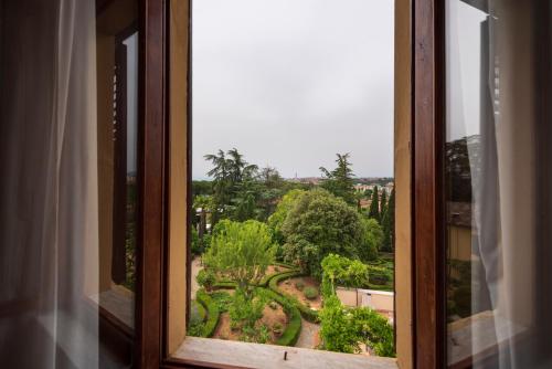 a view of a garden from a window at Villa Scacciapensieri Boutique Hotel in Siena