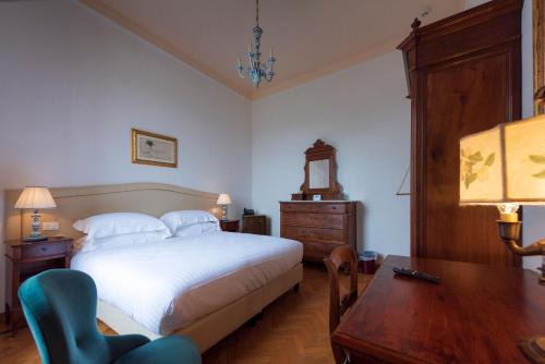 a bedroom with a bed and a table and a desk at Villa Scacciapensieri Boutique Hotel in Siena