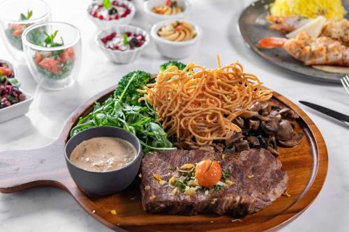 a plate of food with meat and noodles on a table at Park Inn by Radisson, Riyadh in Riyadh